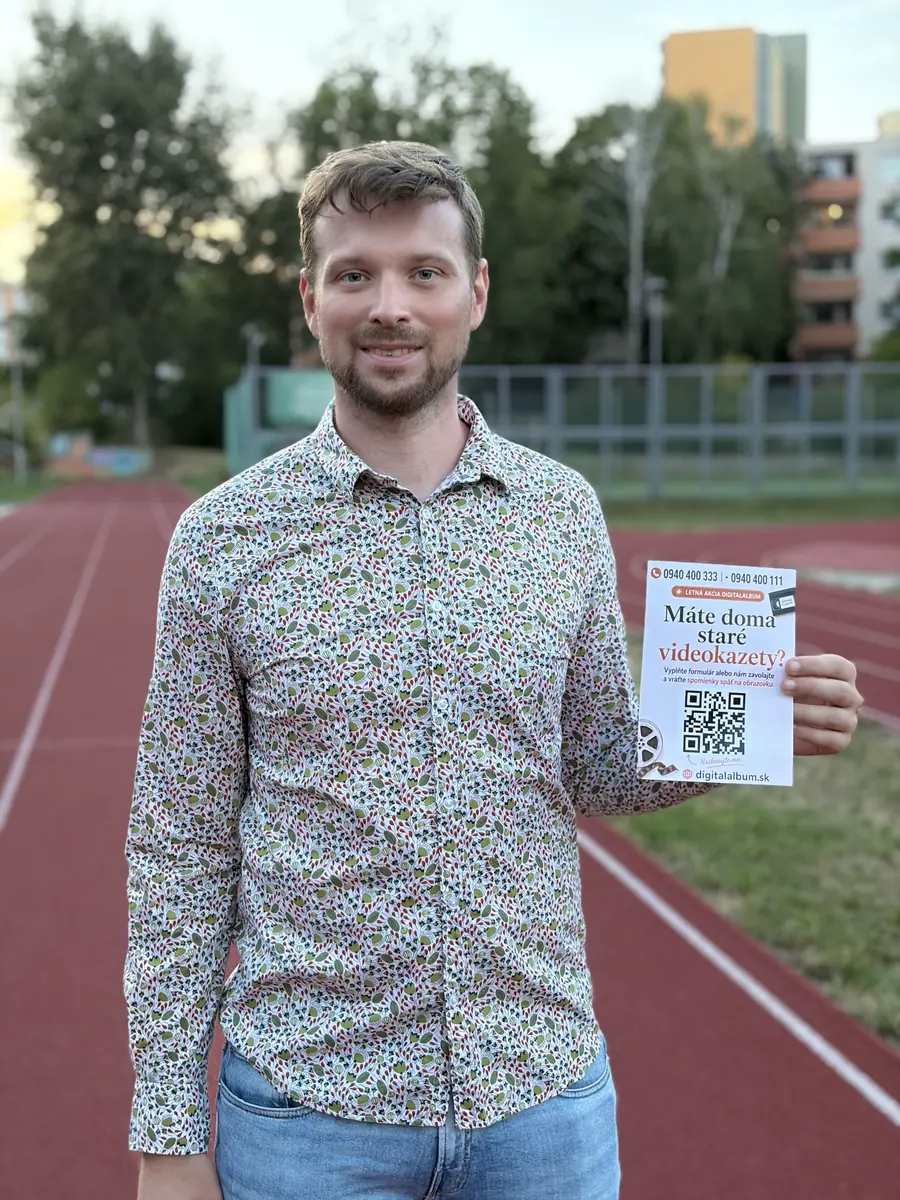 Člen týmu Digitalalbum s plakátem o digitalizaci videokazet